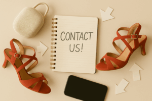 Contact Ubud Studio Bali – red dance heels, smartphone, contact book with Contact Us note on a wooden table